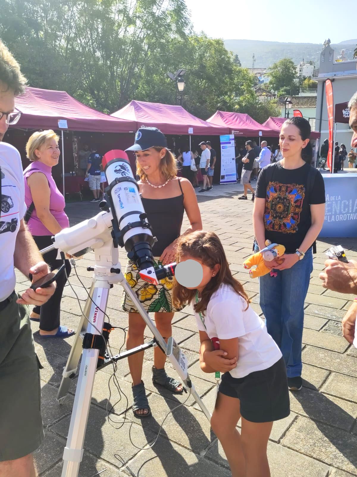 Uan niña mira por un telescopio solar durante la Feria de la Ciencia de la Orotava