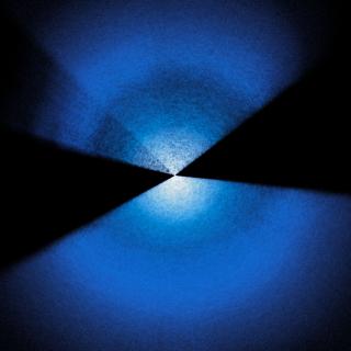 Dos abanicos con lunares azules y blancos que se extienden hacia arriba y hacia abajo desde el centro sobre un fondo negro.