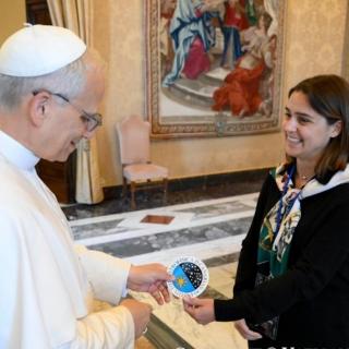 Image of the moment when doctoral students Stella Tsilia and Jun-Yan Zhang (Jerry) present Pope Leo XIV with the sticker bearing the IAC logo. Image of the moment when doctoral students Stella Tsilia and Jun-Yan Zhang (Jerry) present Pope Leo XIV with the sticker bearing the IAC logo.